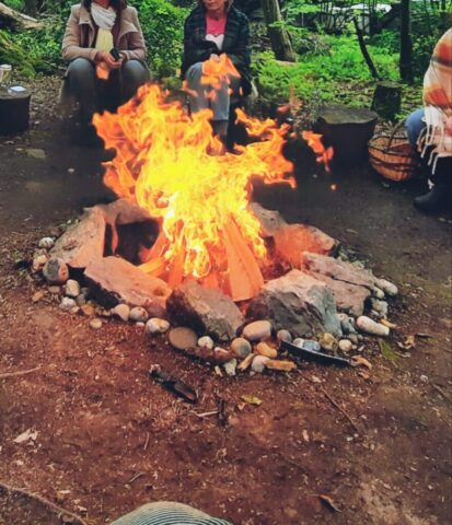 Femmes qui observent flammes d'un feu sacré